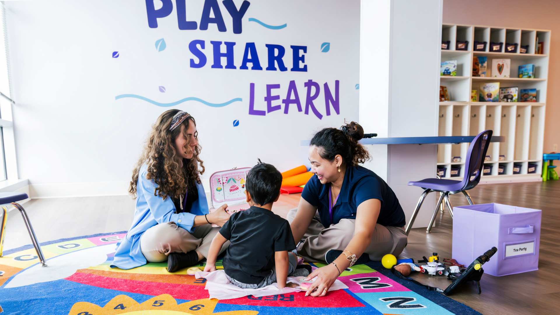 Child and therapist sitting together using toys to practice simple skills