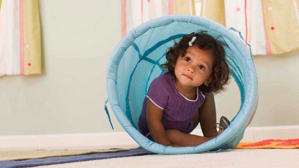 Toddler using sensory tunnel during ABA therapy for toddlers with autism